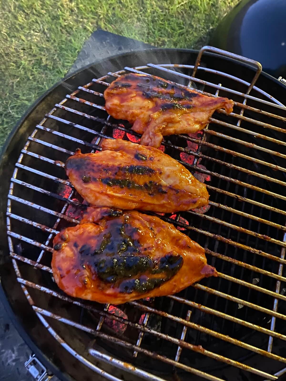 searing marinated chicken breasts on a charcoal smoker grill