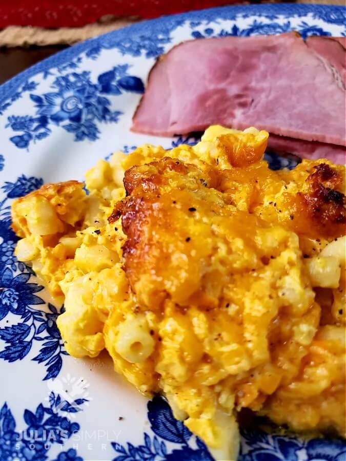 serving of crock pot macaroni and cheese on a blue floral plate with corned beef