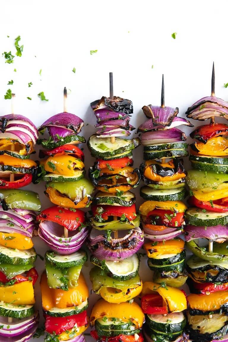 5 vegetable kabobs lined up on white background