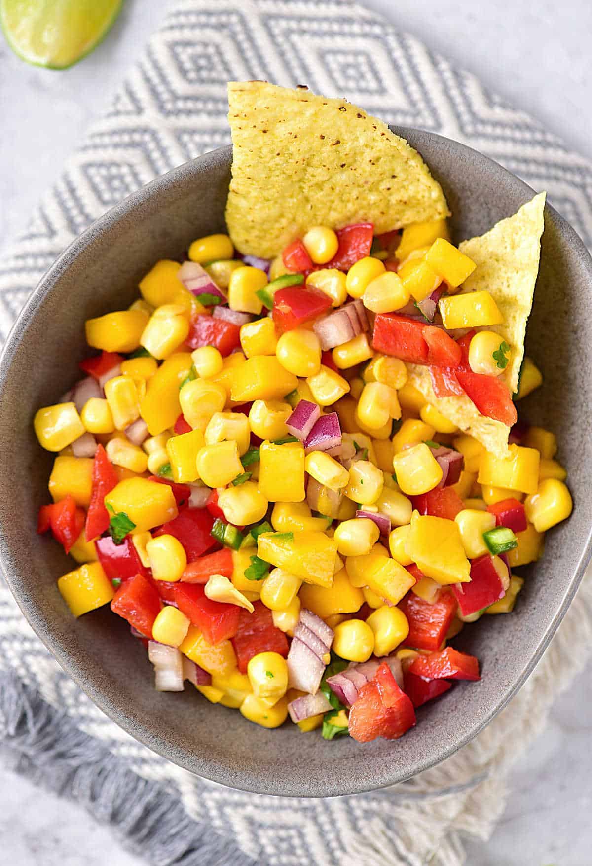 bowl filled with mango corn salsa with tortilla chips