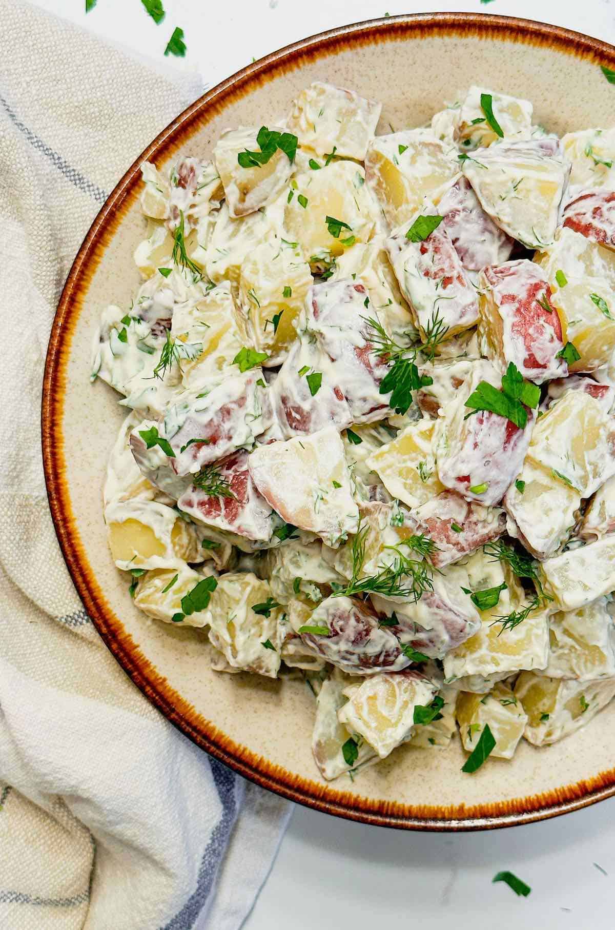 large bowl with red potato salad with dill