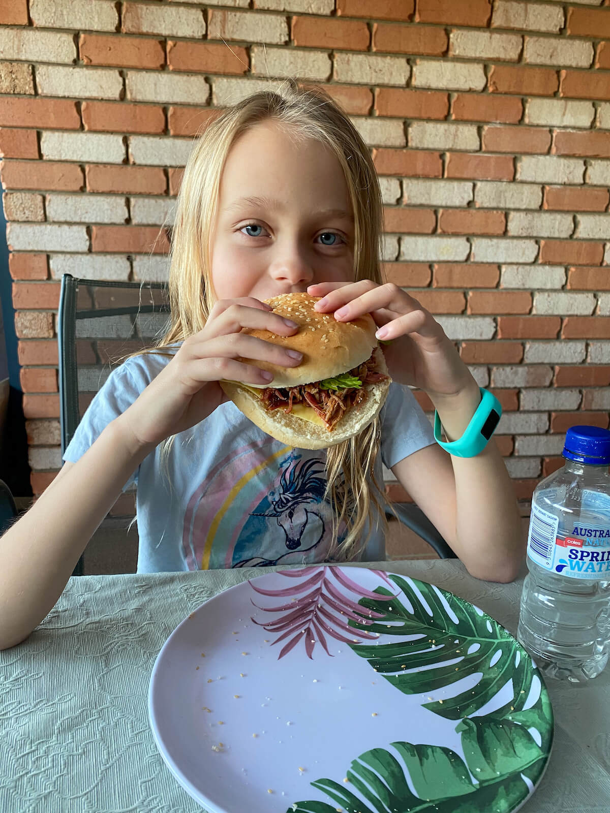 Young girl with a pulled pork burger about to take a bite