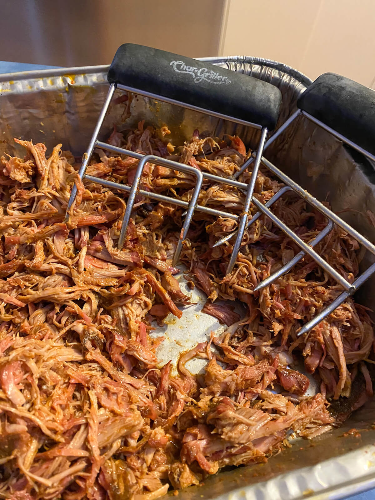 pulled pork with meat claws in a foil dish