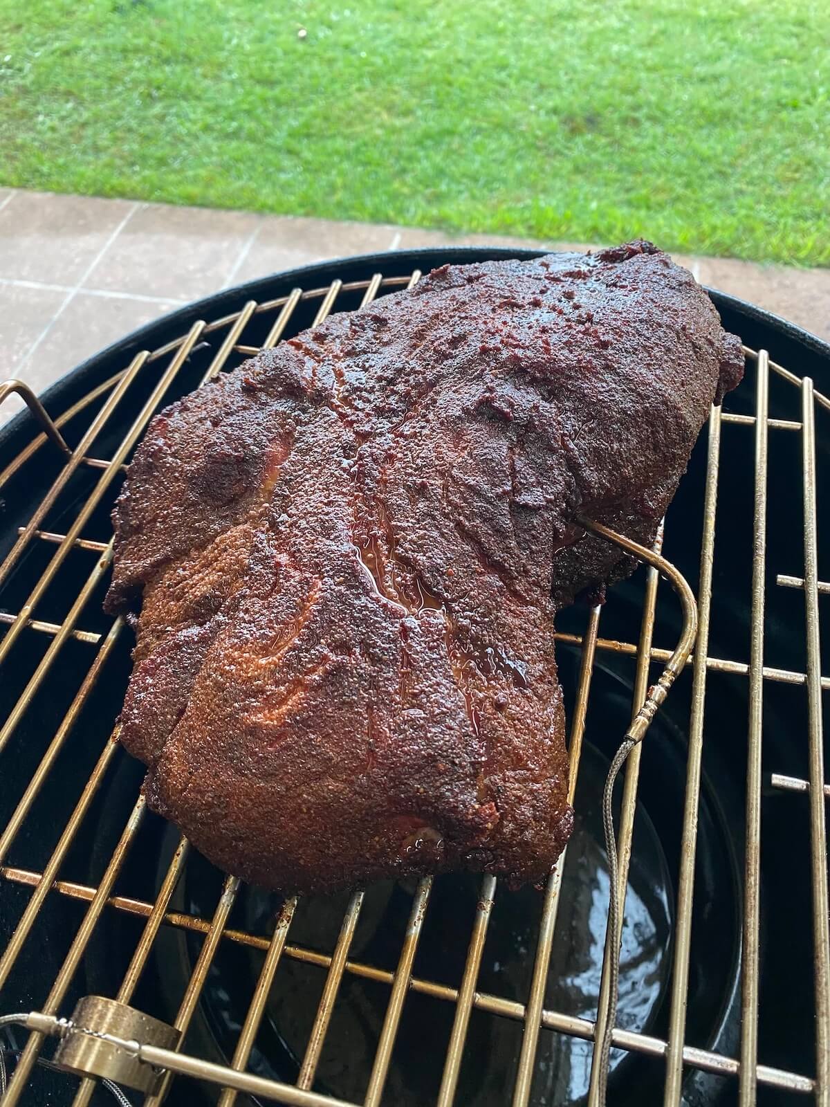 beef brisket on bullet smoker grill plate.