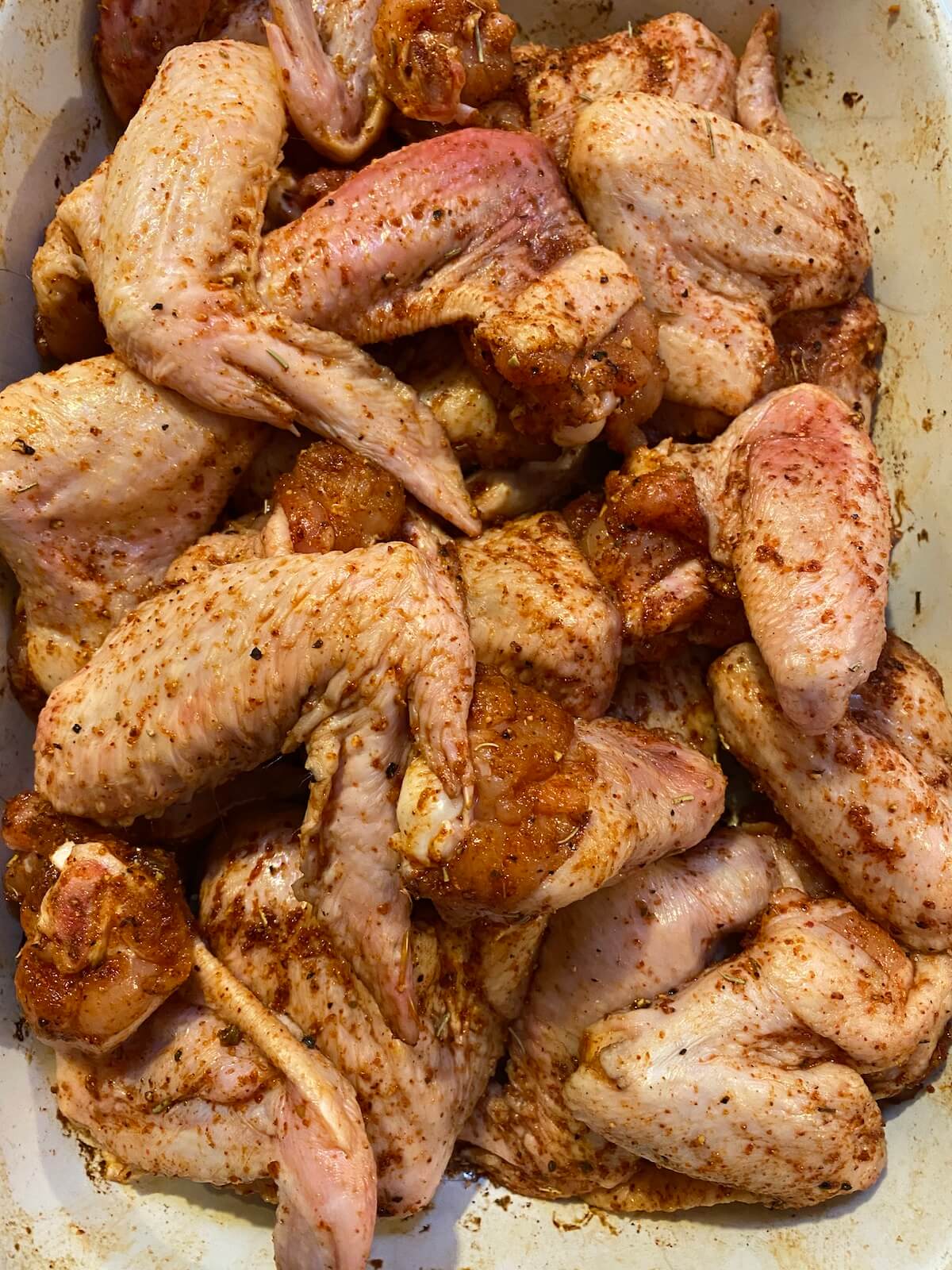 chicken wings with meat rub in preparation for smoking.