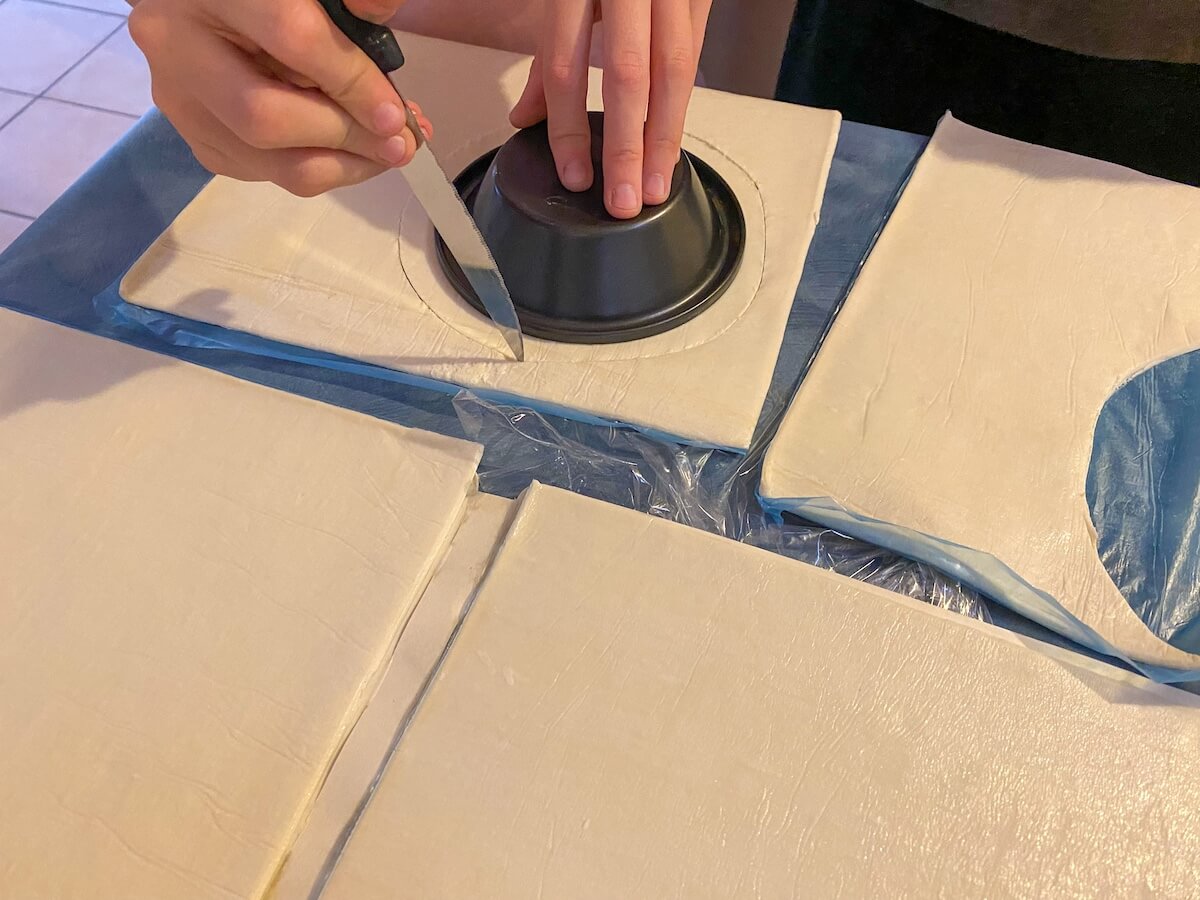 cutting pastry sheets with a pie tray.