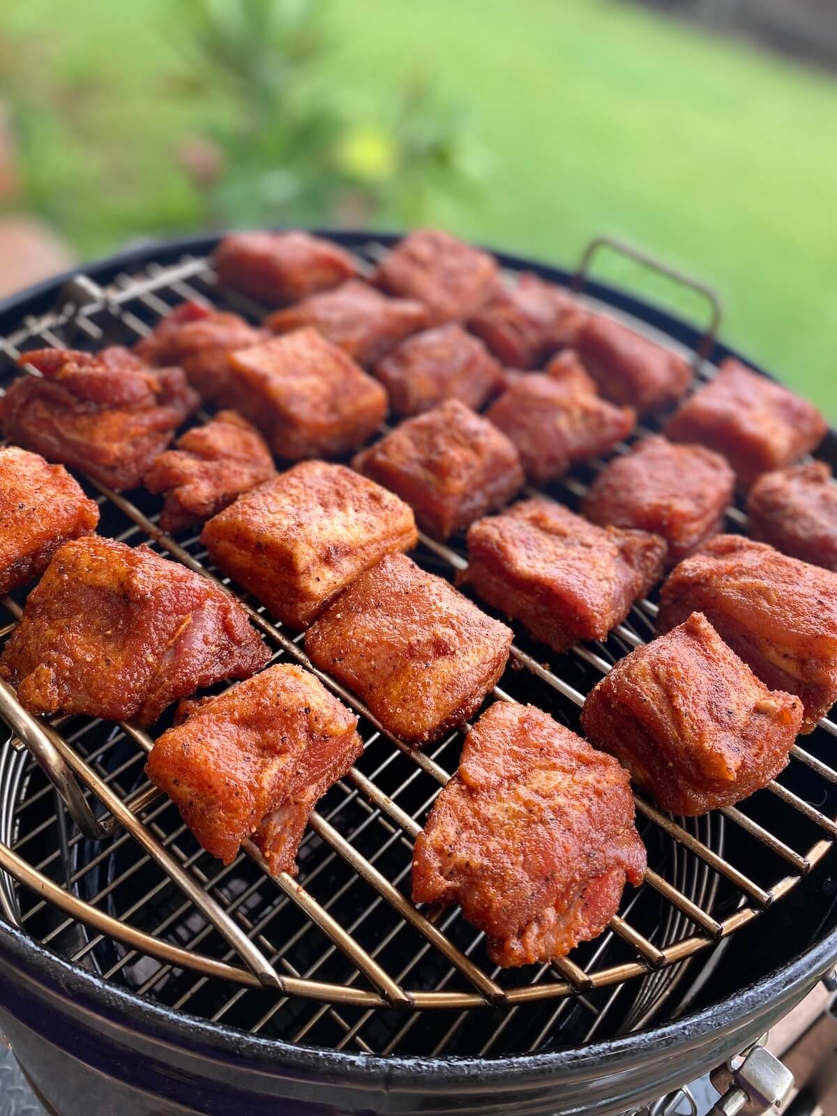 smoked pork belly burnt ends on smoker grill rack.