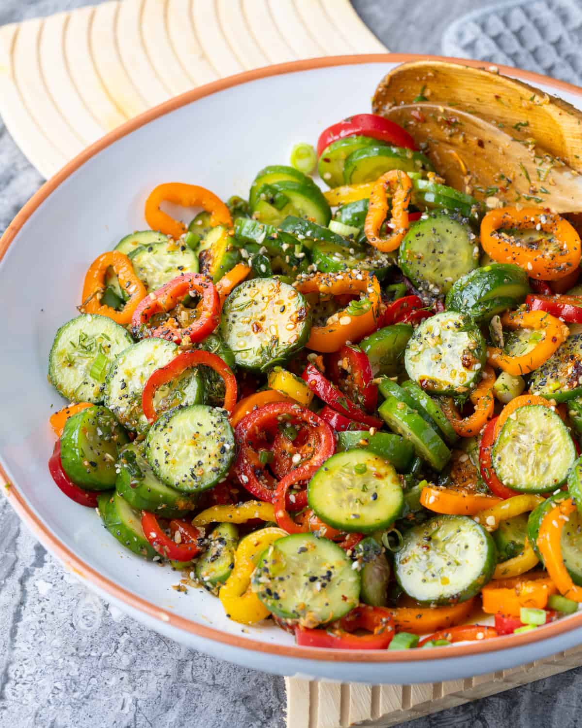 close up of cucumber pepper salad in a large while bowl.