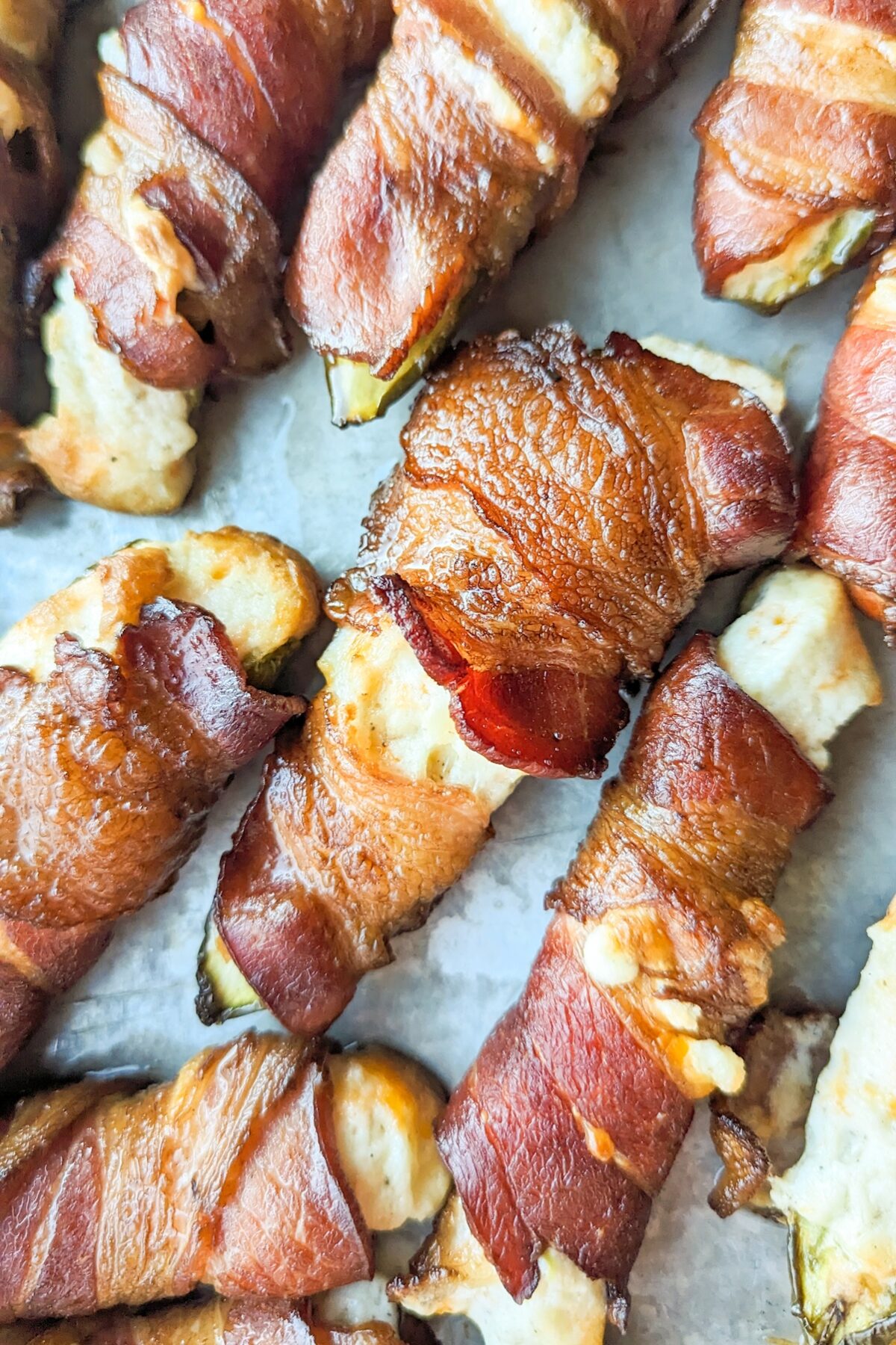 smoked jalapeno poppers on a tray, wrapped in bacon.