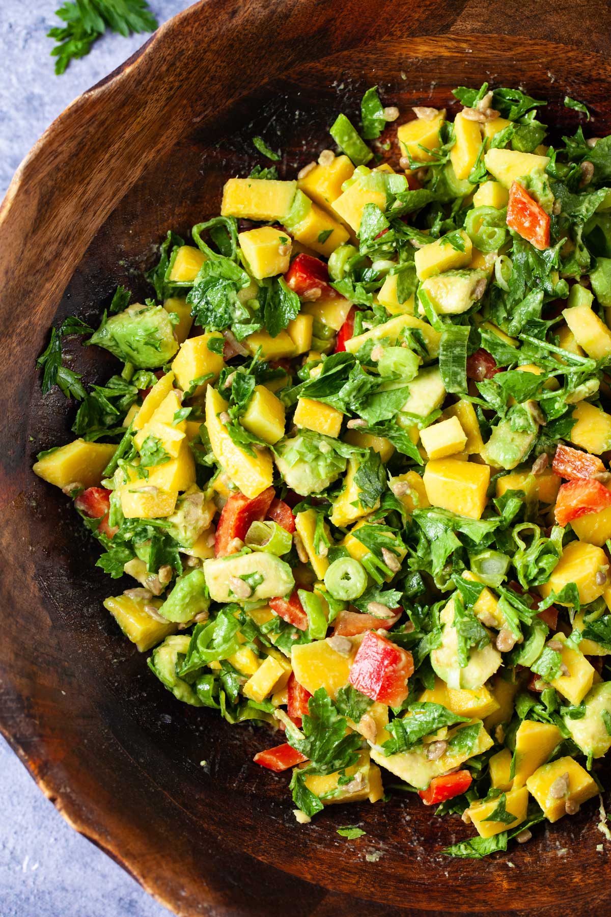 close up of mango avocado salad in a large brown serving bowl.