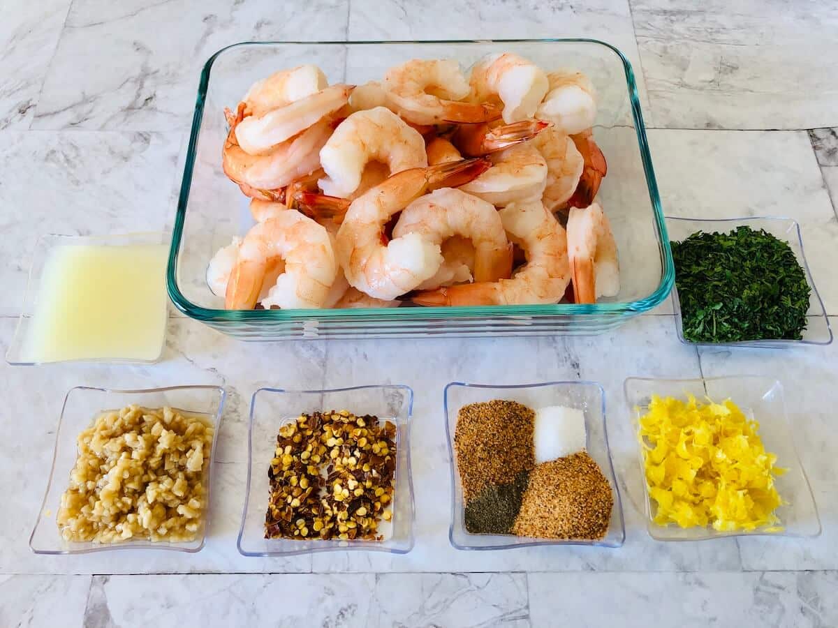 ingredients for lemon and garlic prawns in glass dishes.