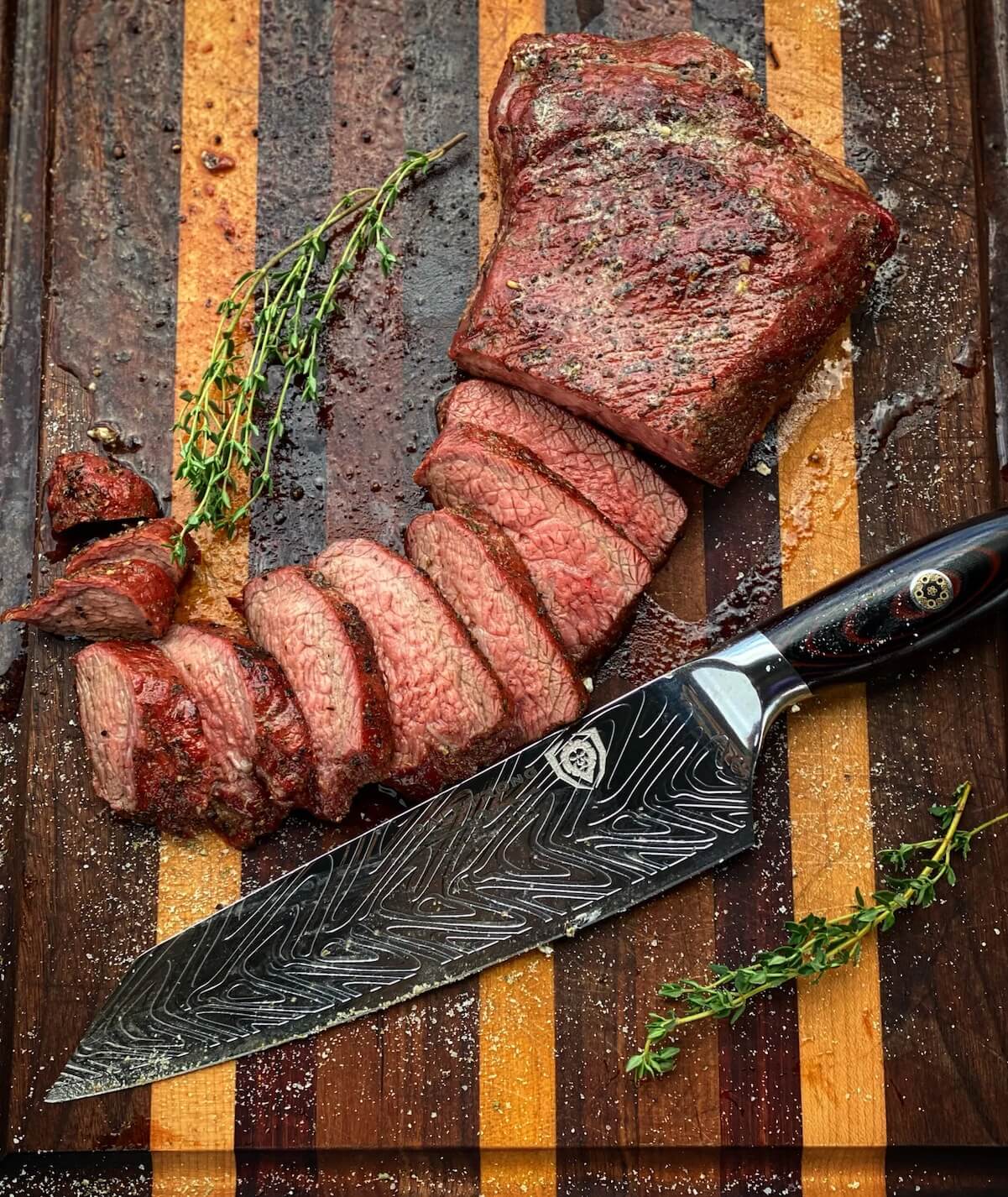 partially sliced tri tip on a wooden board.