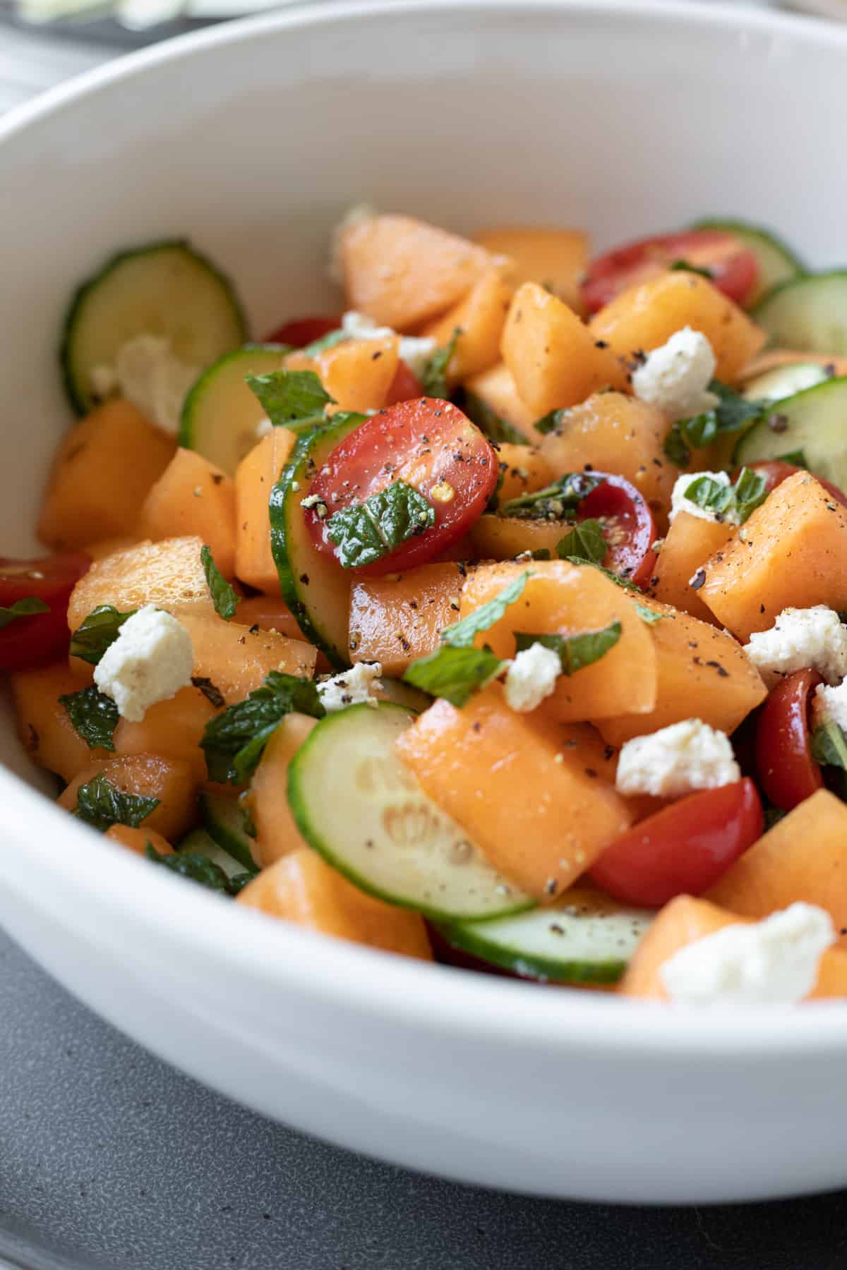 white bowl with cantaloupe salad.