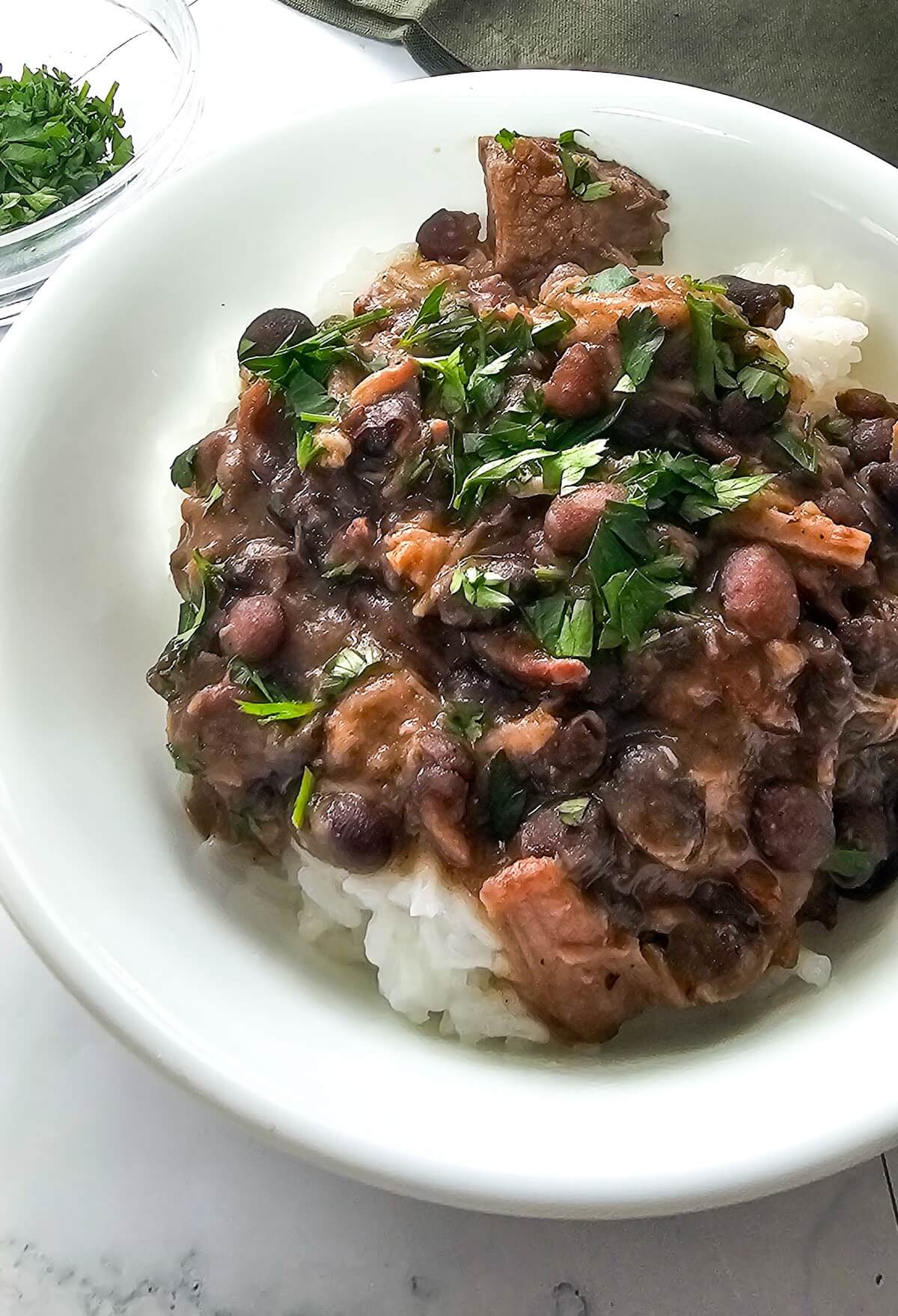 stewed black beans in a large white serving bowl.