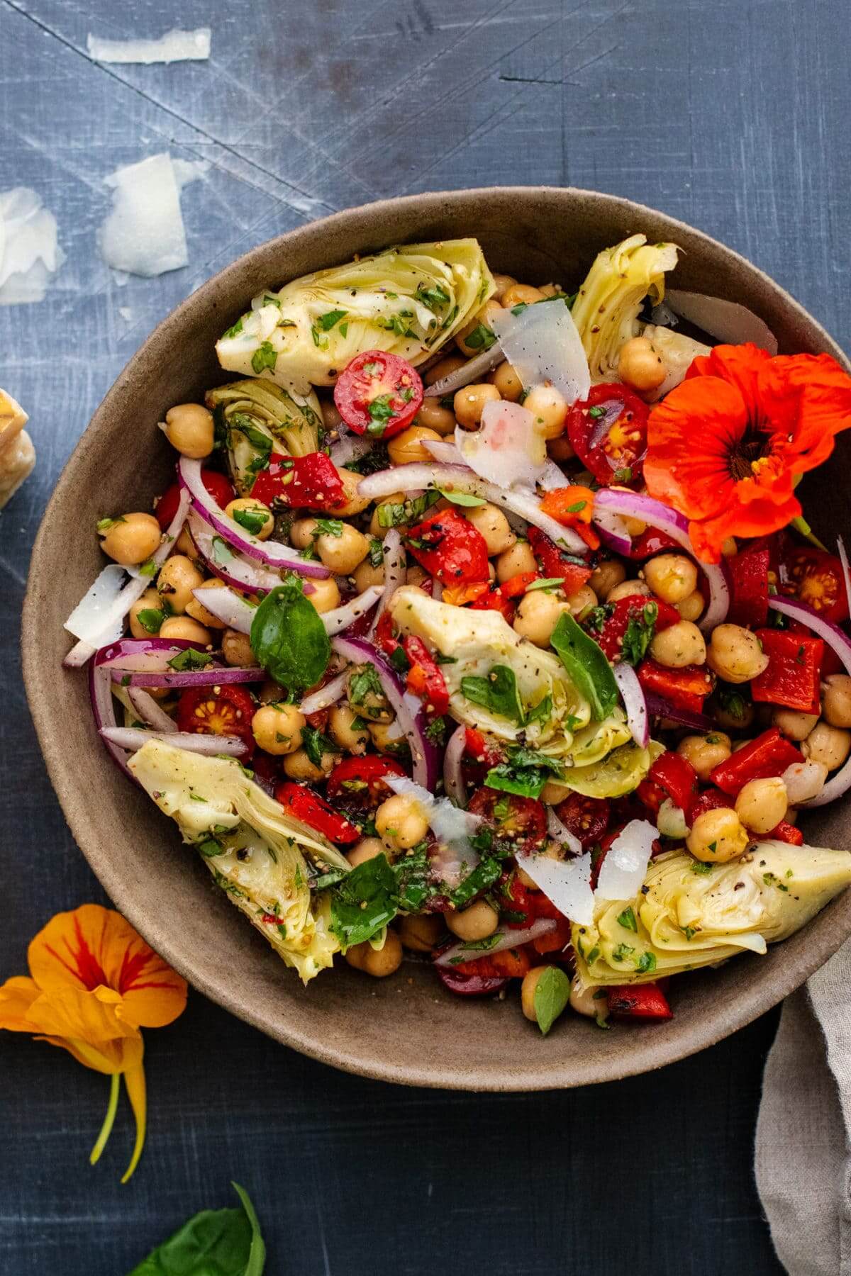 close up of artichoke salad in a brown bowl.