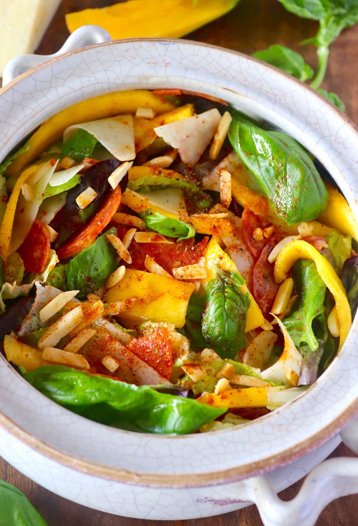 mango and cheese salad in a white bowl.