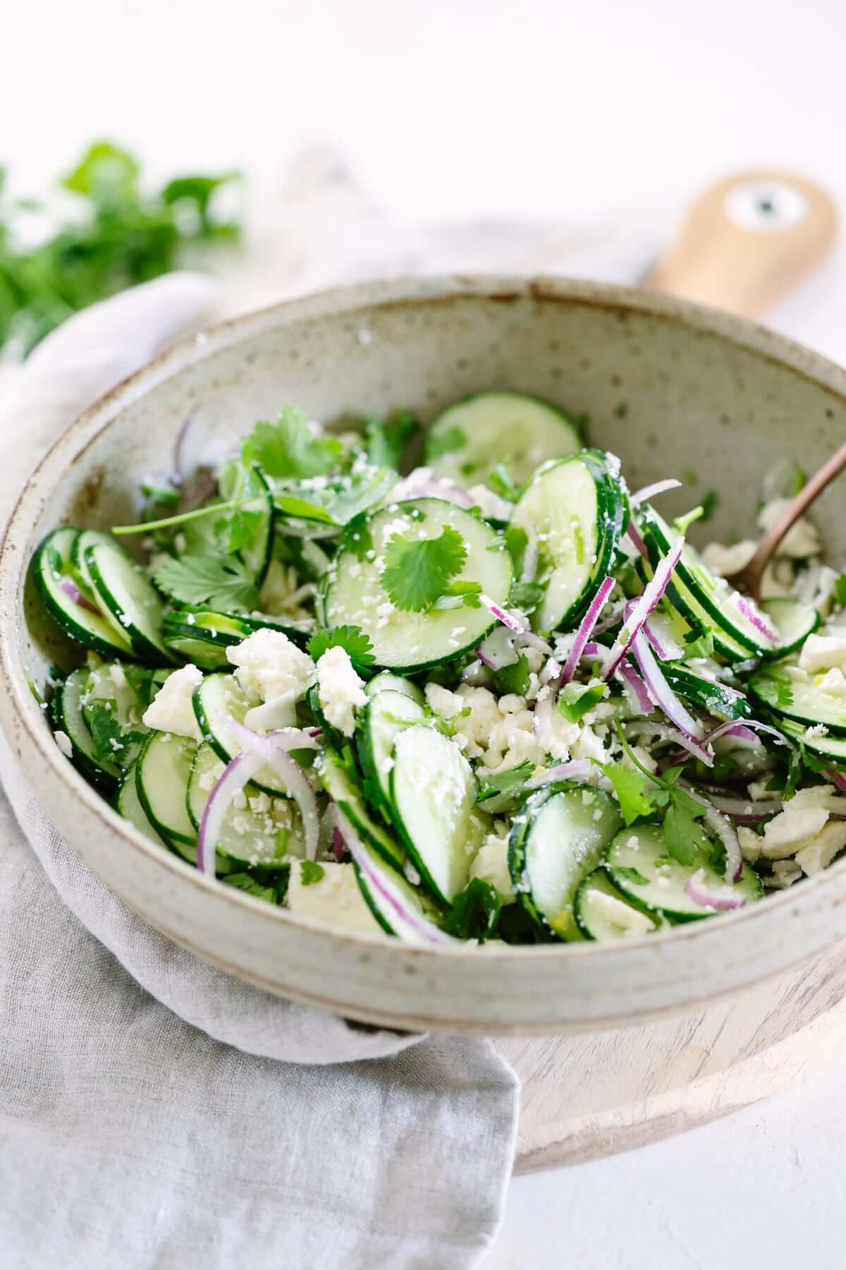 cucumber salad with lime dressing in a white bowl.