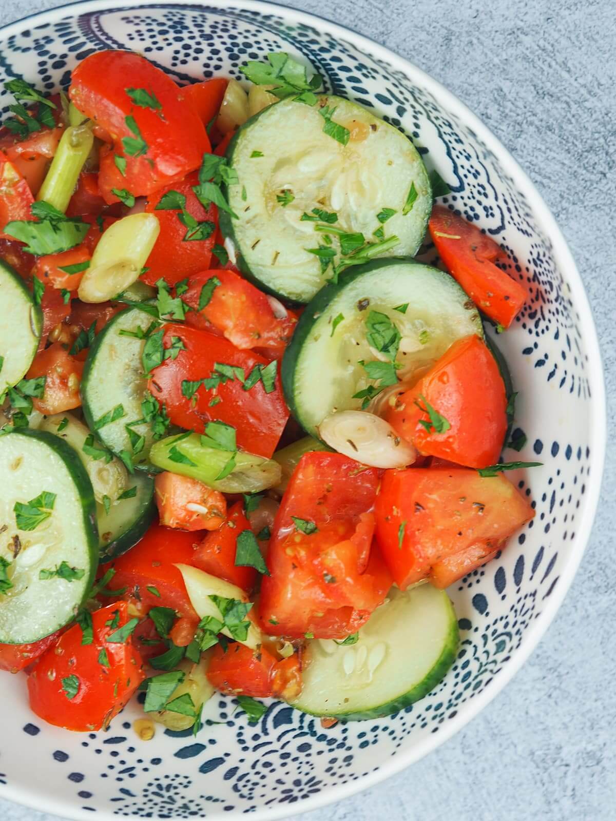 tomato cucumber salad in a glass bowl.