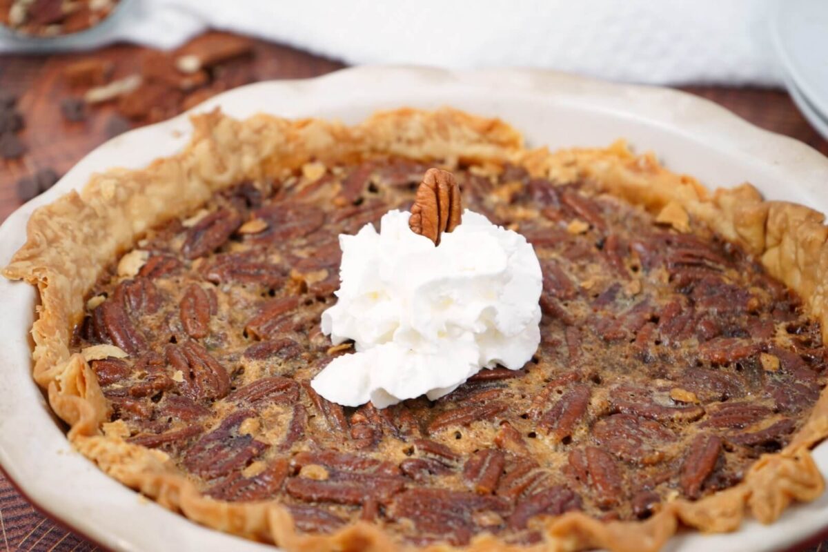 chocolate smoked pecan pie in tray with dollop of cream.