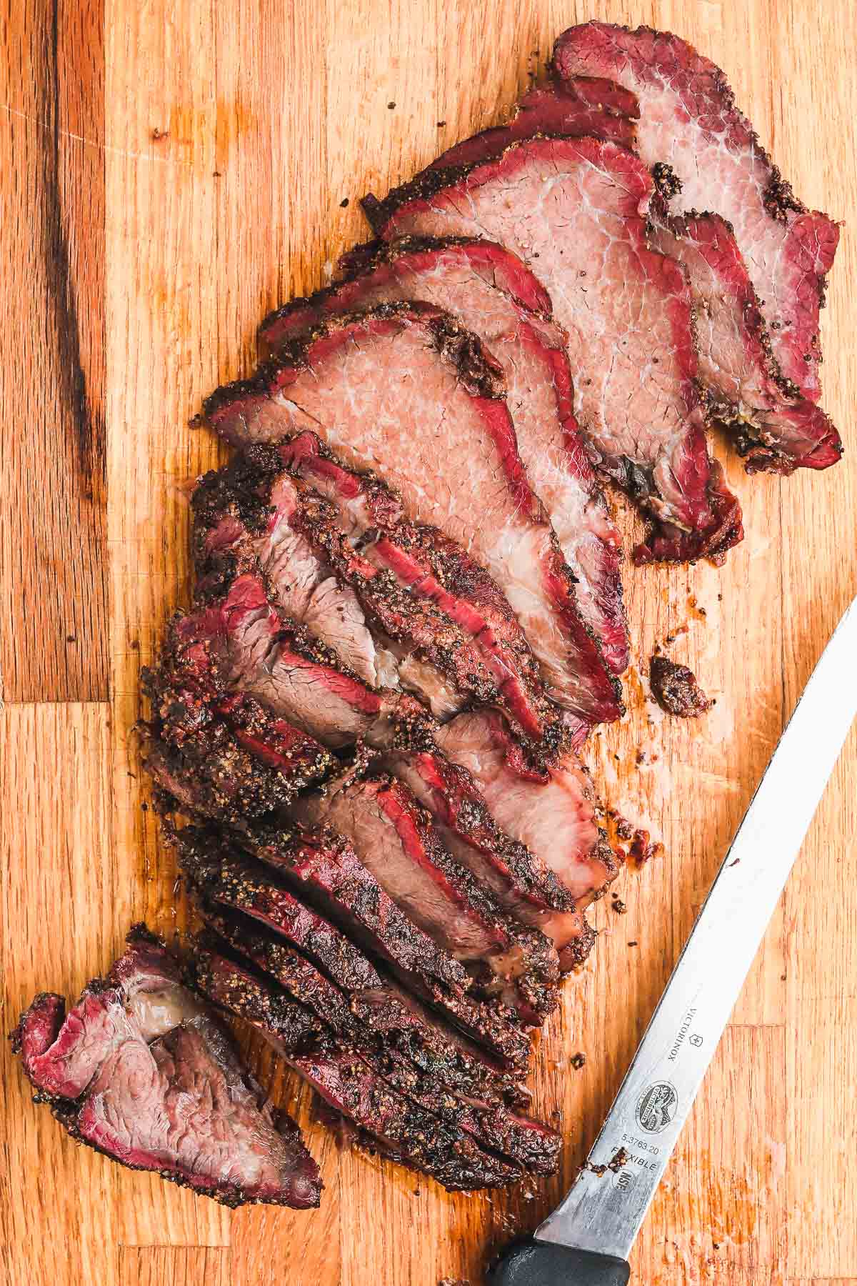 smoked beef chuck roast sliced on board.