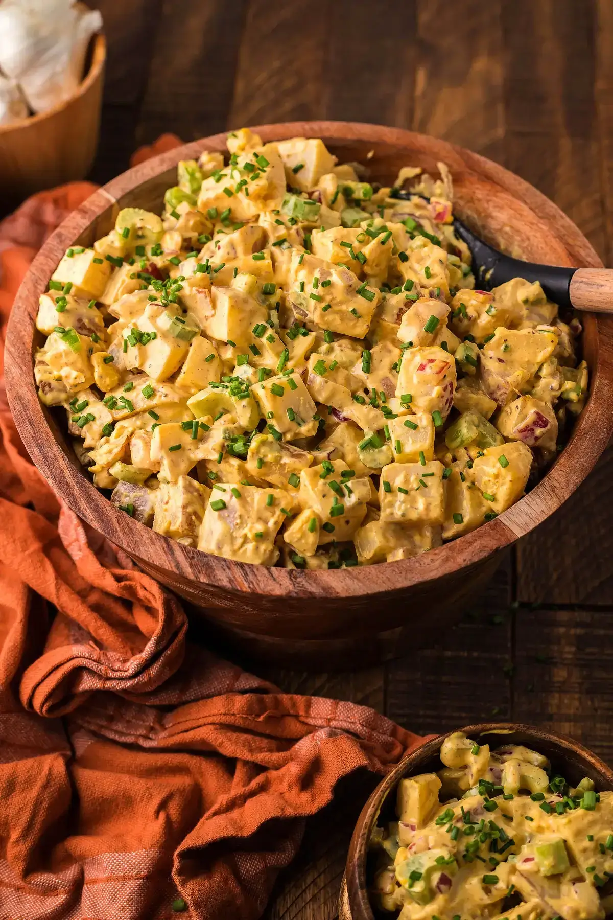 smoked potato salad with bacon in wooden bowl.